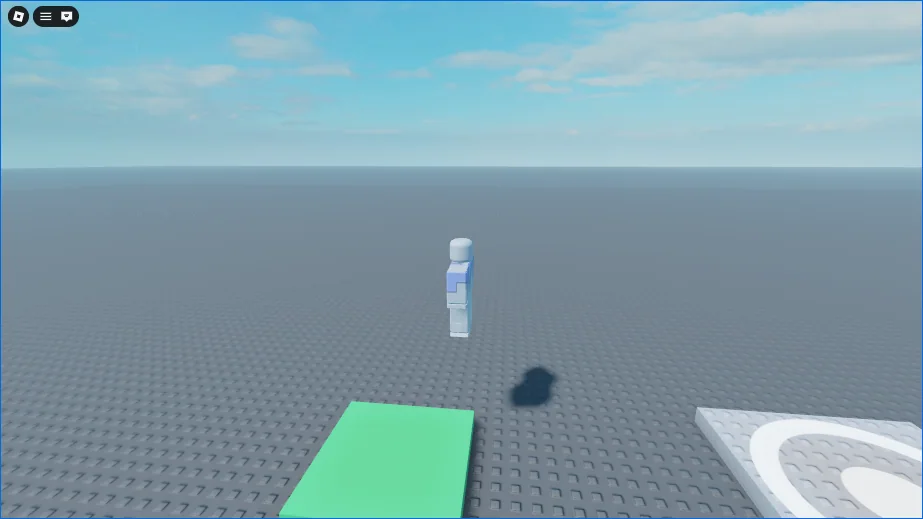 The camera turned to the side and pulled back after a right-drag and the wheel. The character is in the air beyond the green Pad with its shadow on the ground below it, and a corner of the spawn shows on the right.