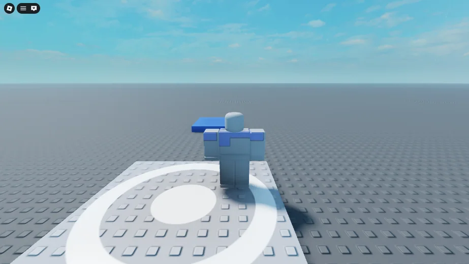 The Roblox View once Play has started. The character stands on the white spawn of a plain grey baseplate under a blue sky, seen from behind, and the blue Pad lies flat on the ground a little way ahead.